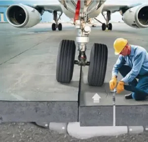 Technician on airport runway working beneath the surface
