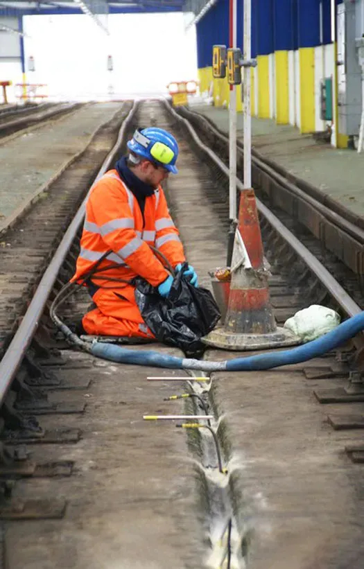 URETEK technician seated while working on railway