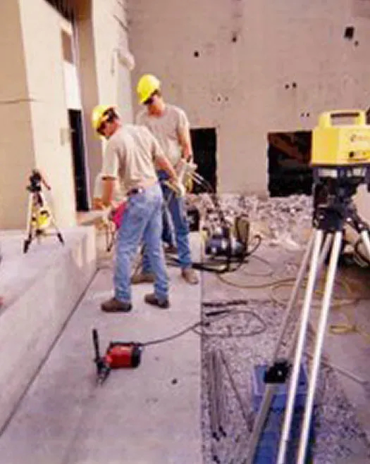 Two URETEK technicians in T shirts and safety helmets