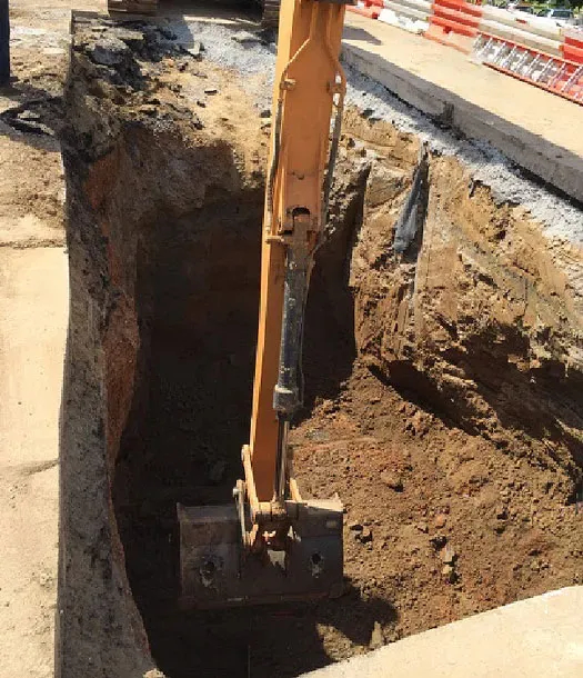 Large construction scoop repairing sinkhole