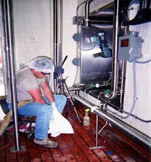 Vintage photo of worker next to large tank