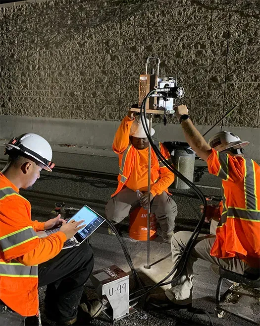 Three URETEK technicians analyze roadway at night