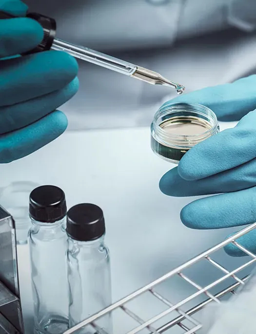 Gloved hands drop sample into vial