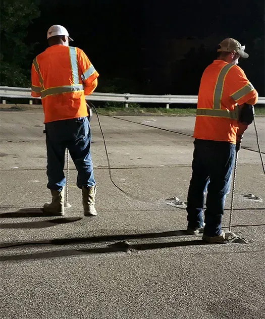 Two URETEK crews drill holes at night