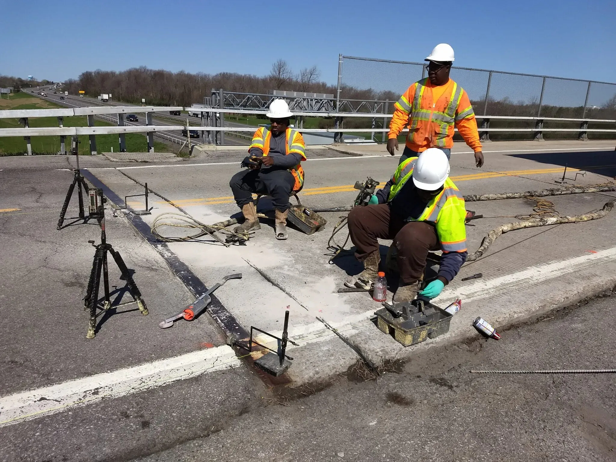 Three URETEK technicians drilling hole in Buffalo roadway