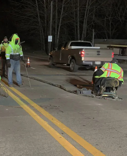 Two technicians work at night on roadway